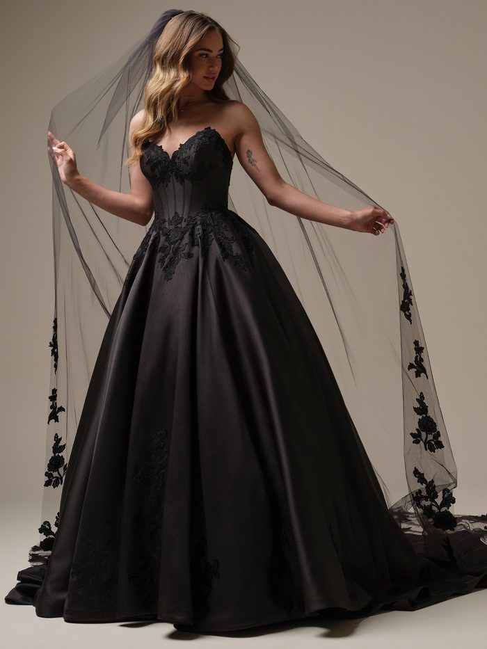 Serafina by Maggie Sottero ballgown wedding dress in black, featuring a strapless sweetheart neckline, illusion corset bodice with floral lace appliqués, and a dramatic satin skirt. Front view showcases the gown paired with a cathedral-length black veil adorned with matching floral lace accents.