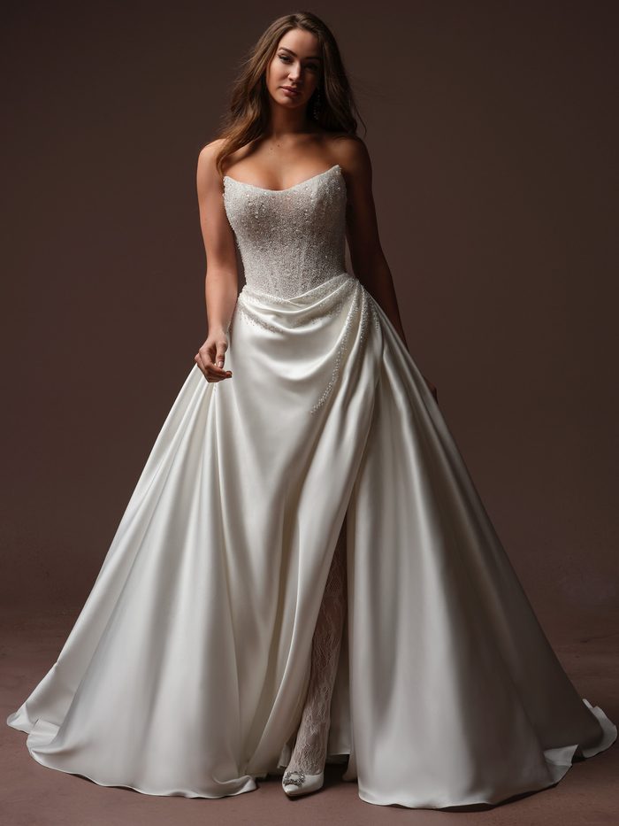 Rumi by Sottero and Midgley ballgown wedding dress with a beaded strapless bodice and draped satin skirt.