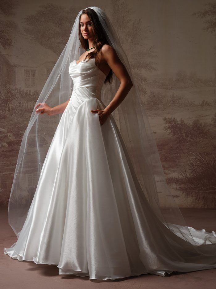 Bride wearing Rosamund by Maggie Sottero, a dramatic organza ballgown wedding dress with a full skirt and draped bodice.
