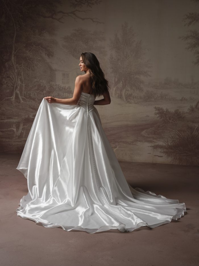 Back view of Rosamund by Maggie Sottero showcasing covered buttons trailing down a voluminous skirt.